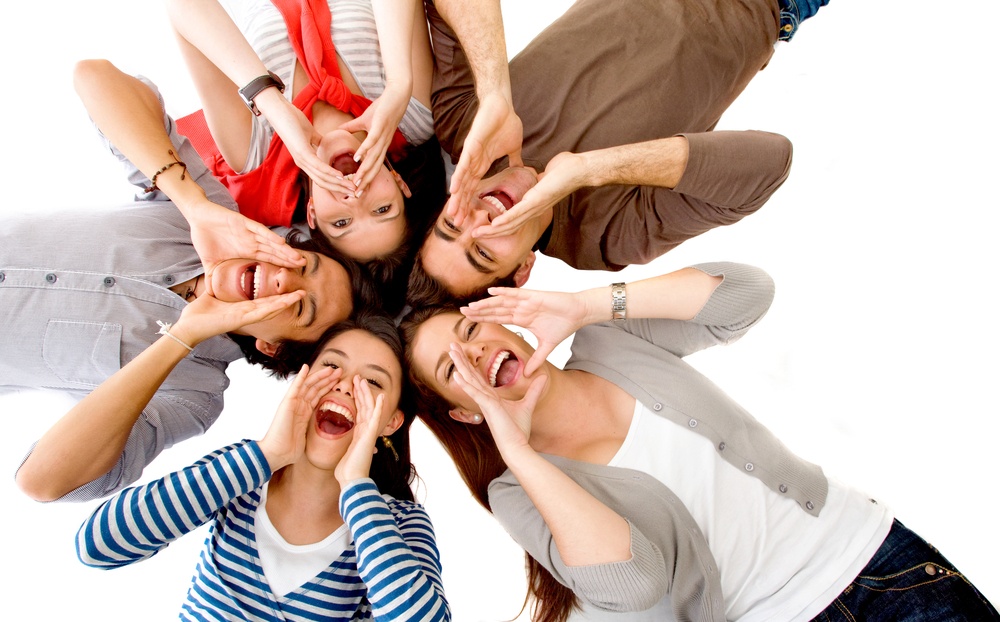 Friends shouting on the floor with their heads together isolated over a white background